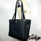 oversized quilted black tote bag resting on the shoulder of a dressform