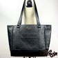 quilted oversized large black designer tote bag resting on the shoulder of a dressform